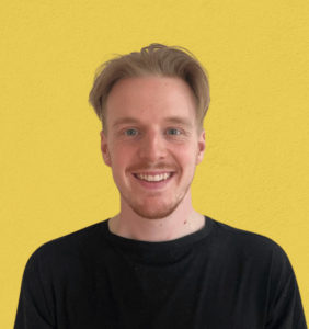 headshot of ben in a black shirt on a yellow background