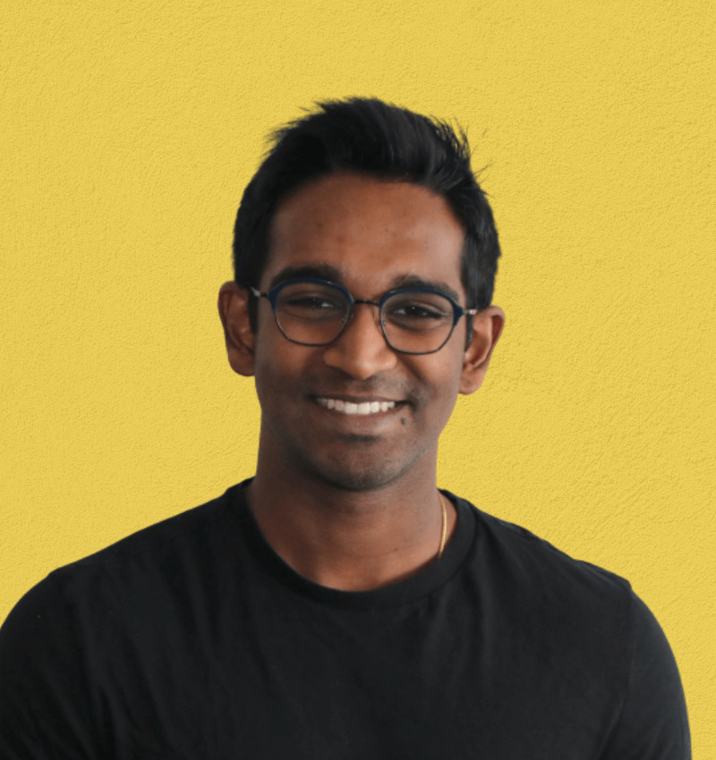headshot of Tarish in a black shirt on a yellow background