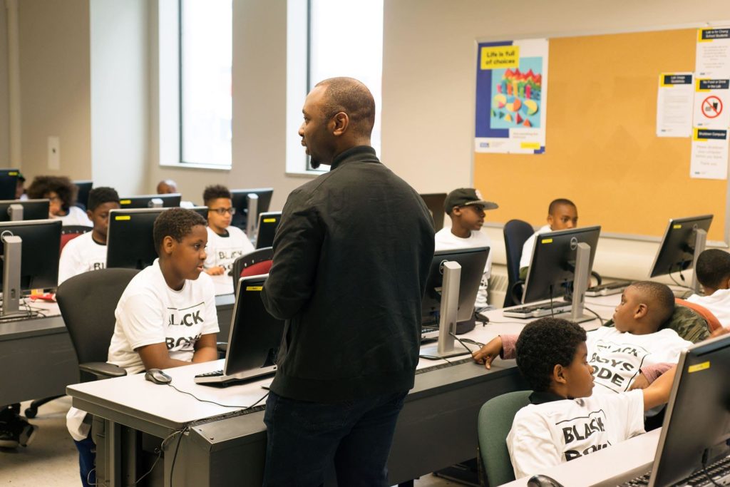 A volunteer from Black Boys Code teaching a coding class