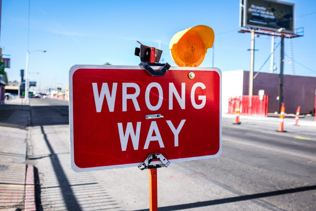 Picture of a sign board with the words 'wrong way' written on it. 